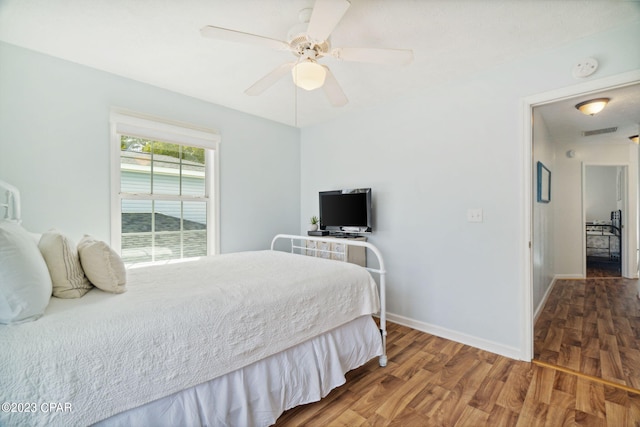 bedroom with dark hardwood / wood-style floors and ceiling fan