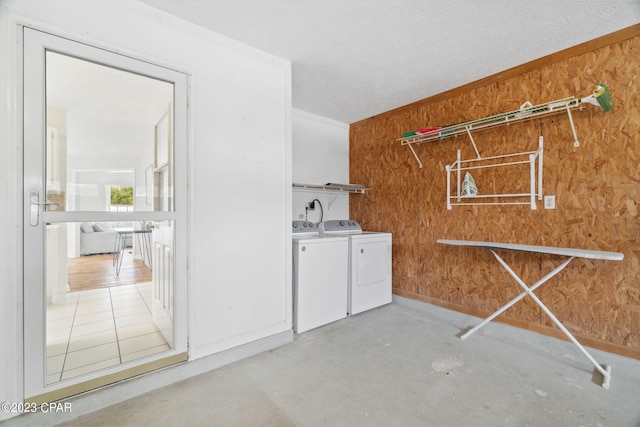 washroom featuring washer and clothes dryer and wood walls