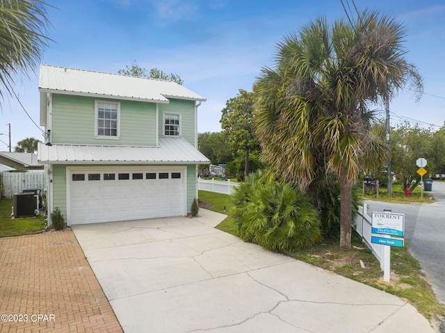 view of front of property featuring central AC unit and a garage