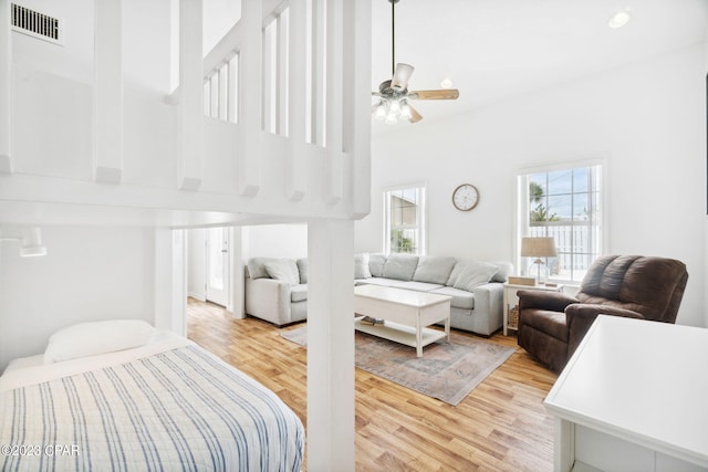 bedroom featuring a towering ceiling and light hardwood / wood-style flooring