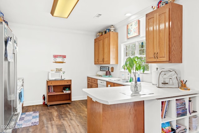 kitchen with white appliances, kitchen peninsula, dark hardwood / wood-style flooring, and crown molding