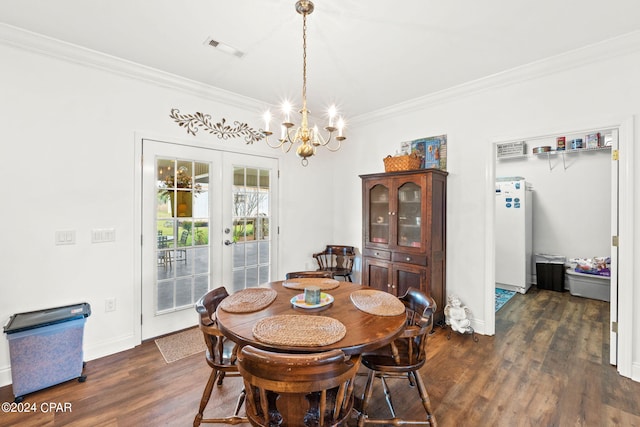 dining area featuring an inviting chandelier, dark wood-type flooring, crown molding, and french doors