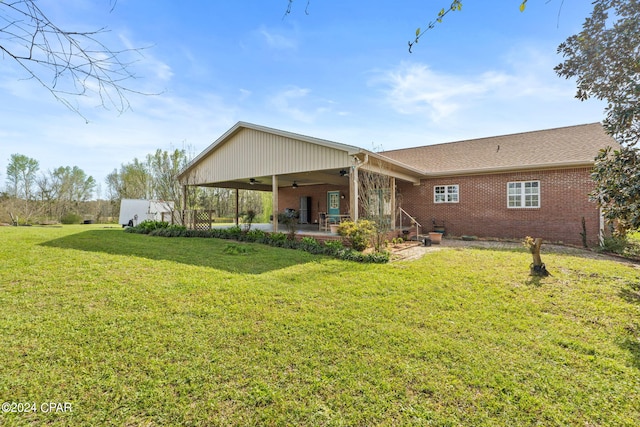 rear view of house with a yard, ceiling fan, and a patio area