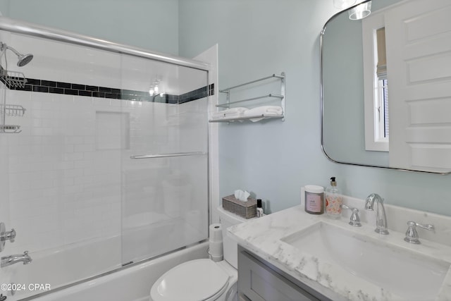 full bathroom featuring oversized vanity, combined bath / shower with glass door, and toilet