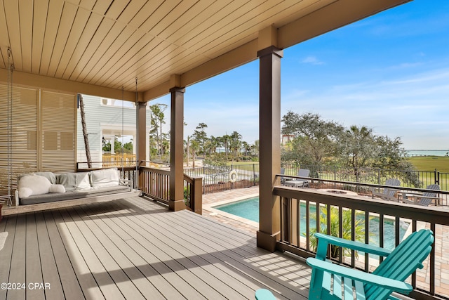 deck with outdoor lounge area and a fenced in pool