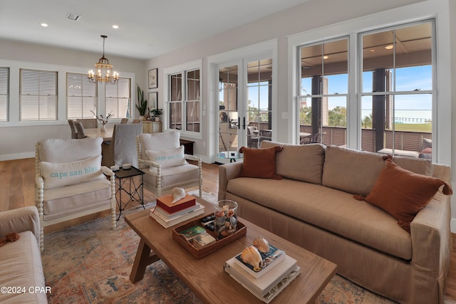 living room with an inviting chandelier, french doors, and hardwood / wood-style flooring