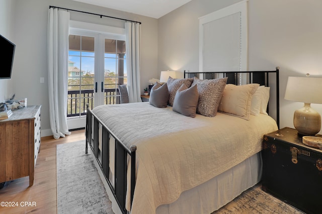 bedroom with access to outside, light hardwood / wood-style floors, and french doors