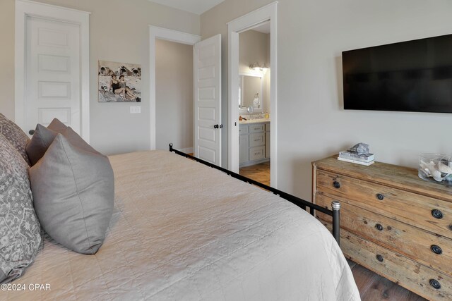 bedroom with connected bathroom and light wood-type flooring