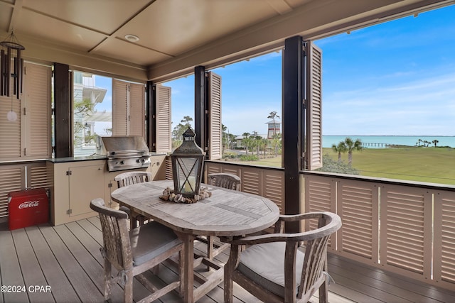 wooden terrace with a grill and a water view