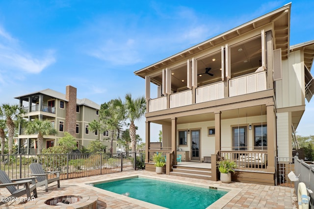 rear view of house with a balcony, a fenced in pool, a patio, and ceiling fan