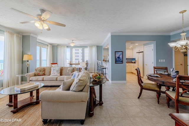 living room with a textured ceiling, ornamental molding, ceiling fan with notable chandelier, and light tile floors