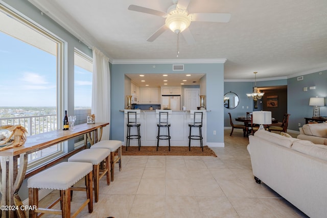 tiled living room featuring a textured ceiling, crown molding, and ceiling fan with notable chandelier