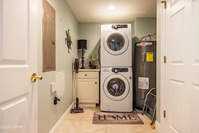 clothes washing area featuring stacked washer / drying machine, electric water heater, light tile floors, and cabinets