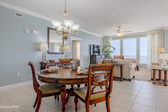 tiled dining area featuring a textured ceiling, ceiling fan with notable chandelier, and ornamental molding