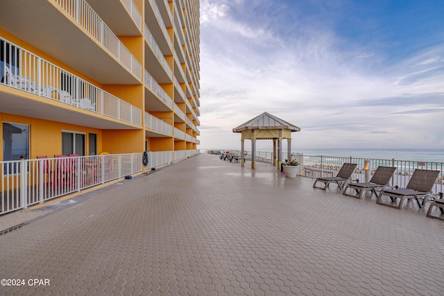 view of patio featuring a balcony, a gazebo, and a water view