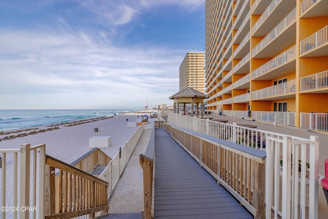 view of property's community with a view of the beach, a gazebo, and a water view