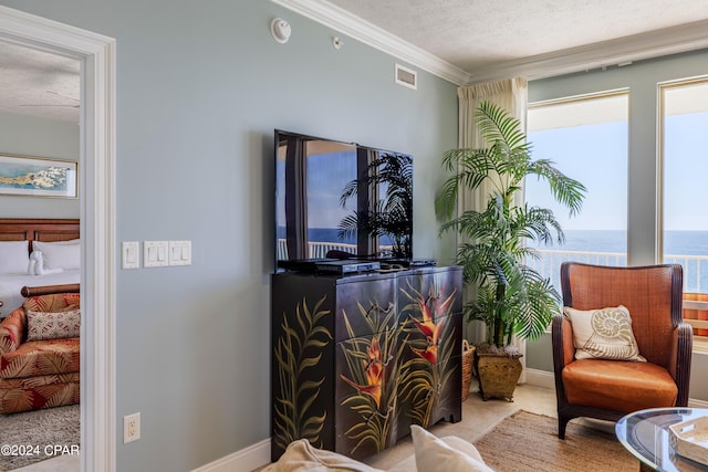 living area with crown molding, light tile flooring, a textured ceiling, and a healthy amount of sunlight