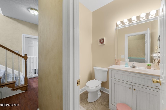 bathroom featuring tile patterned floors, vanity, toilet, and baseboards