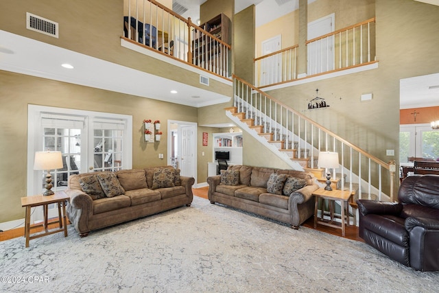 living room with stairway, baseboards, visible vents, and wood finished floors