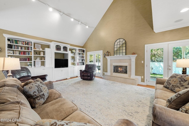 living room featuring high vaulted ceiling, french doors, and a fireplace