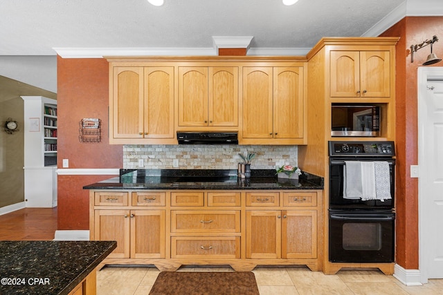 kitchen with black appliances, under cabinet range hood, dark stone counters, and crown molding