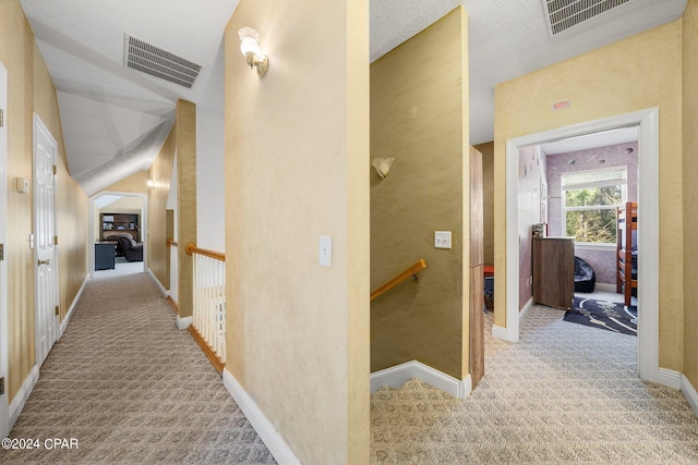 hallway with light carpet, baseboards, visible vents, and an upstairs landing