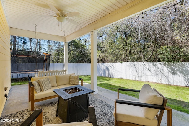 view of patio / terrace with a trampoline, a fenced backyard, and a fire pit