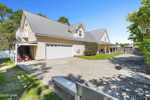 view of front facade with an attached garage, fence, metal roof, and concrete driveway