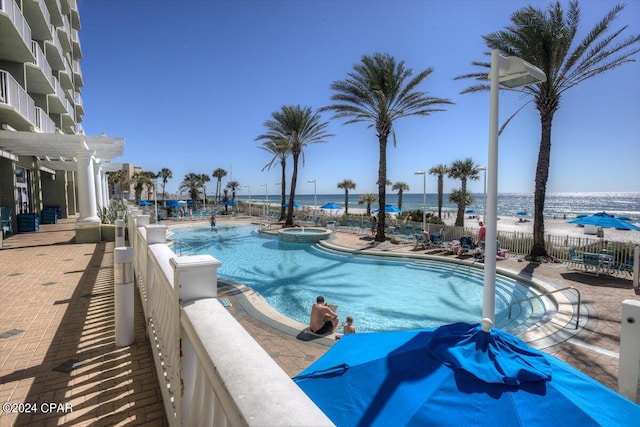 pool featuring a water view, a patio area, fence, and a pergola