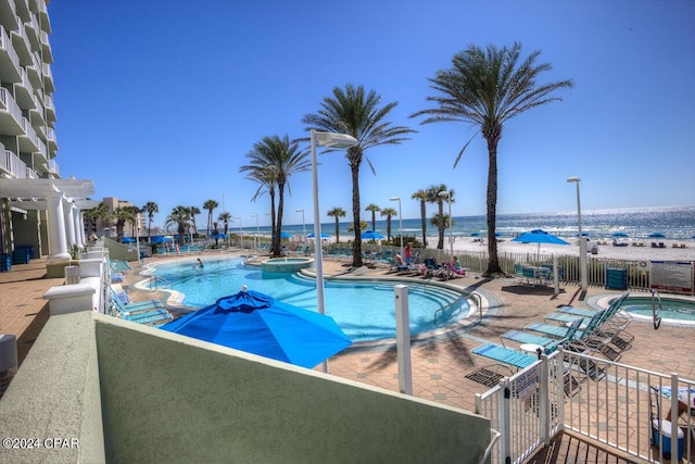 pool featuring a community hot tub, a patio area, fence, and a pergola