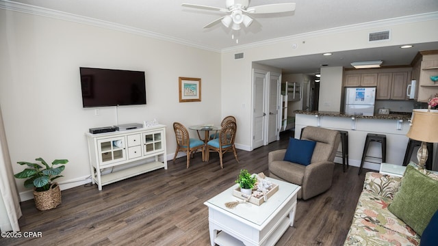 living area with visible vents, crown molding, and wood finished floors