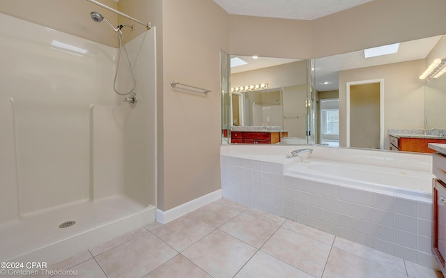 bathroom with a shower, tile floors, vanity, and a skylight