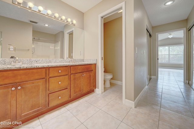 bathroom featuring toilet, ceiling fan, double sink vanity, and tile flooring