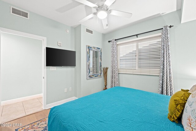 bedroom with ceiling fan and light tile floors