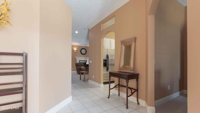 hall with light tile floors and a textured ceiling