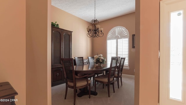 carpeted dining space featuring an inviting chandelier, a textured ceiling, and a wealth of natural light