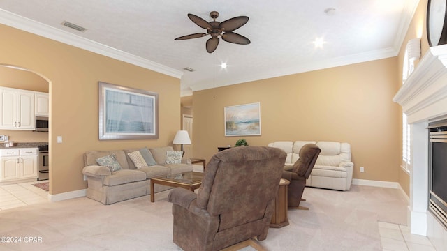 carpeted living room with crown molding and ceiling fan