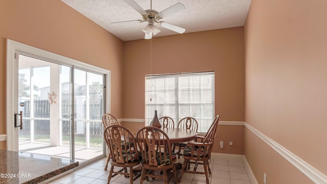 tiled dining room featuring ceiling fan, a textured ceiling, and a wealth of natural light