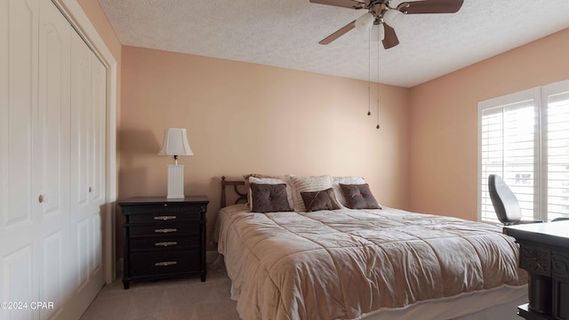 carpeted bedroom featuring a textured ceiling and ceiling fan