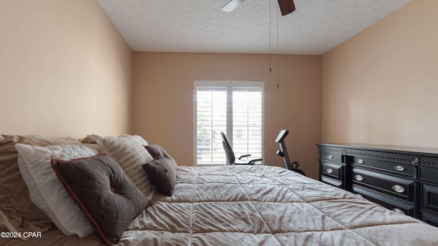 bedroom with ceiling fan and a textured ceiling