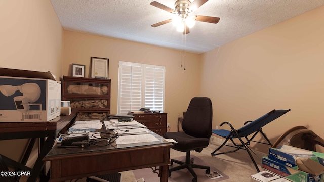 carpeted office space with a textured ceiling and ceiling fan