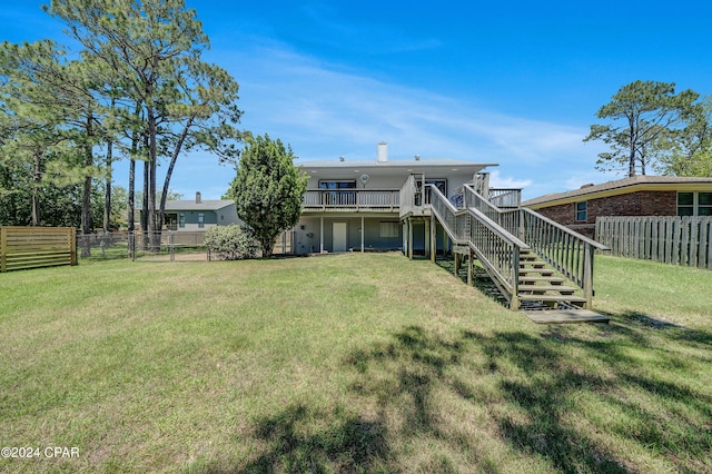 back of property featuring a lawn and a wooden deck