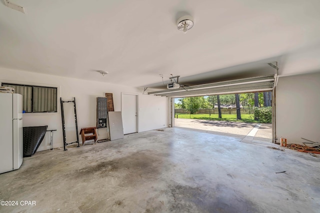 garage featuring a garage door opener and white fridge