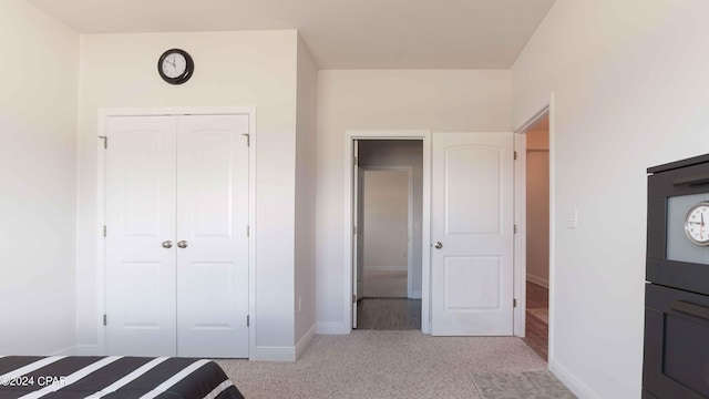 unfurnished bedroom featuring light carpet and a closet