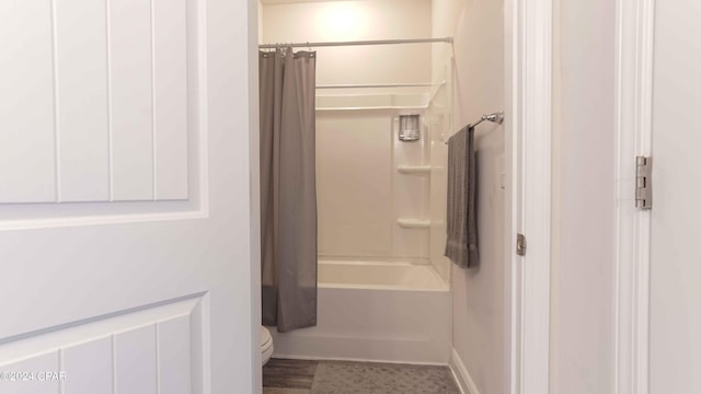 bathroom featuring toilet and shower / tub combo