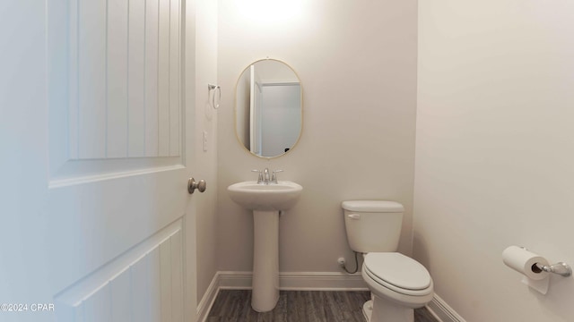 bathroom with hardwood / wood-style floors and toilet