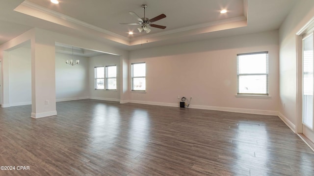 unfurnished room featuring dark wood-type flooring, crown molding, a raised ceiling, and ceiling fan with notable chandelier