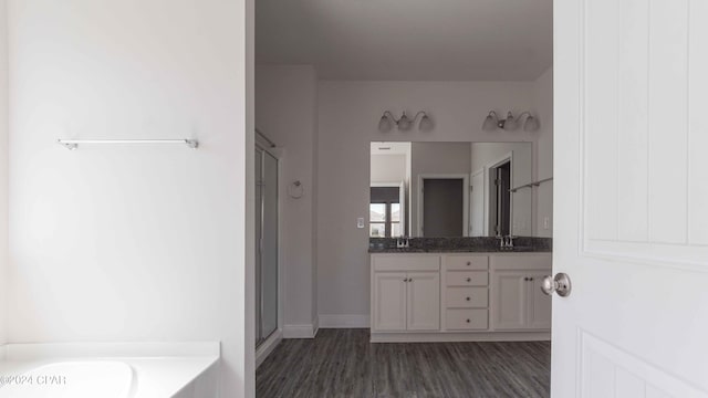 bathroom with hardwood / wood-style flooring, vanity, and shower with separate bathtub