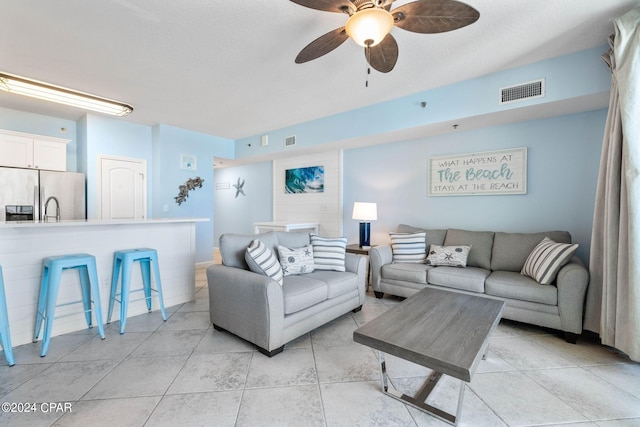 living room with light tile floors and ceiling fan