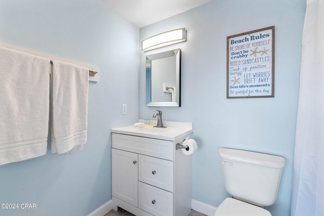 bathroom with toilet and vanity with extensive cabinet space